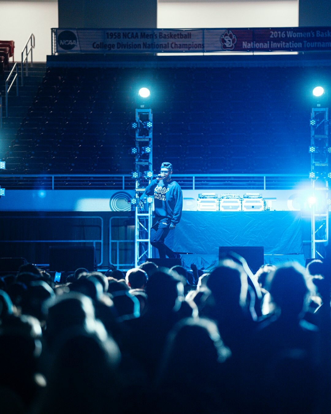 Moderator on stage speaking to a large conference audience