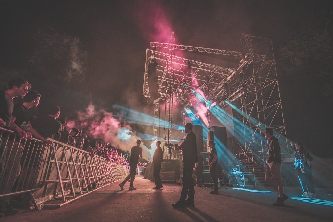 Outdoor festival stage at dusk with colorful lights